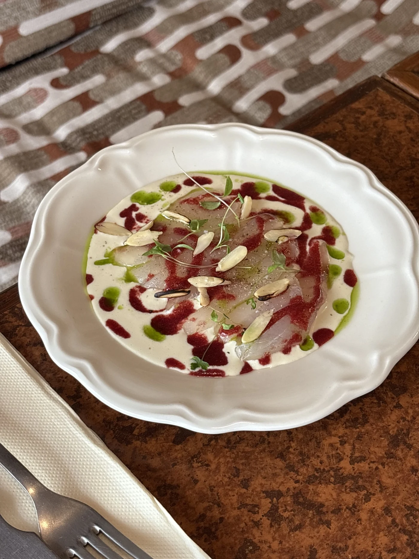 Assiette de poisson cru, sauce crémeuse, huiles colorées et amandes au déjeuner du Caméo